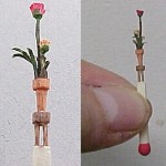 Спичка с цветком в горшке на табуретке